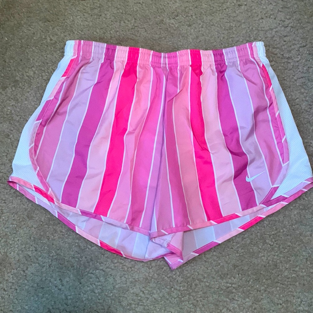 Different shades of pink , with white stripes , nike athletic shorts